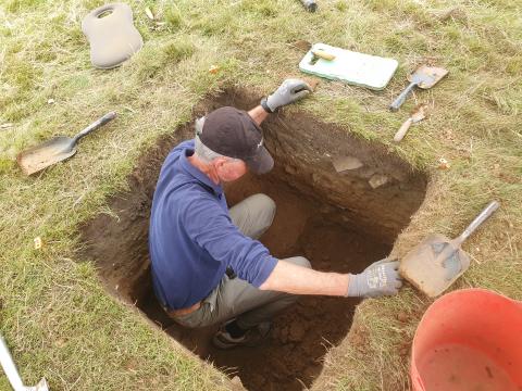 volunteer digging a test pit