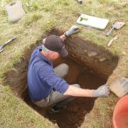 volunteer digging a test pit